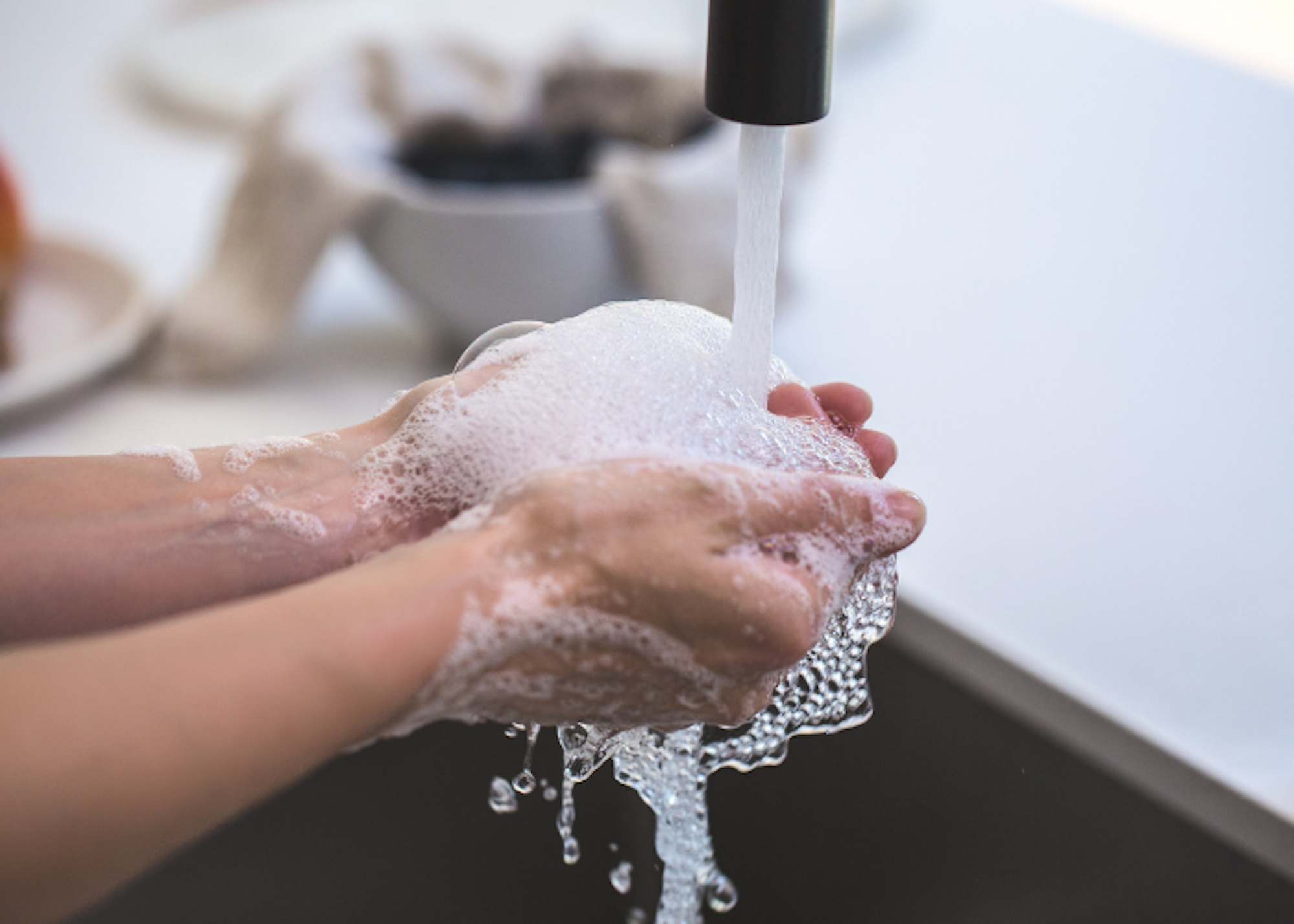 a person washing their hands with a foam soap